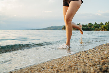 Young woman running or jogging on the beach at sunset	
