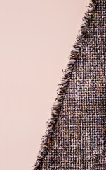 tweed fabric with fringe on beige background, copy space