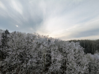 Winter landscape in Germany with frozen frost on trees and fields, drone shot