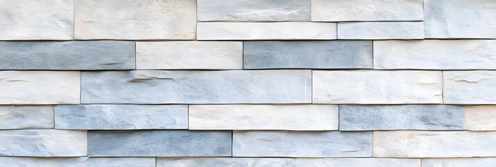 Obraz premium A textured stone wall with a blend of dusty silver grey, pale blue, and soft white hues. The surface has an organic feel with faint cracks and a matte finish. The muted tones and natural design