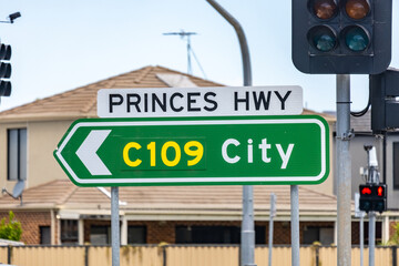 Obraz premium A road sign directs drivers towards Melbourne city via Princes Highway C109, indicating a major thoroughfare and freeway in Australia.