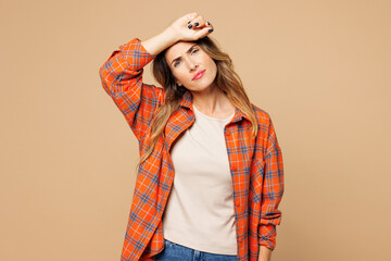 Young sad sick ill tired exhausted woman wear orange shirt casual clothes put hand on forehead...