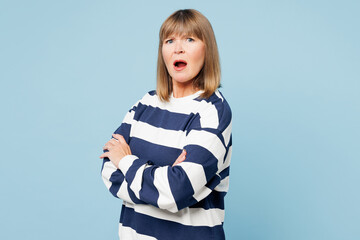 Elderly sad blonde woman 50s years old wear striped sweatshirt casual clothes hold hands crossed...