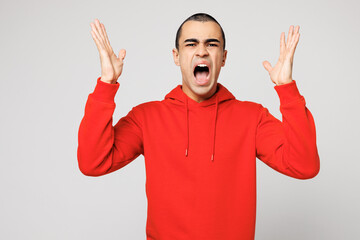 Fototapeta premium Young sad dissatisfied displeased shocked middle eastern man he wear red hoody casual clothes spread hands scream shout cry isolated on plain solid white background studio portrait. Lifestyle concept.