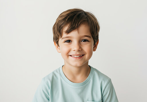Portrait of a laughing boy of 6-7 years old in a T-shirt on a light background