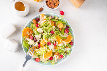 Salad bowl with lettuce, tangerines, nuts and cranberry