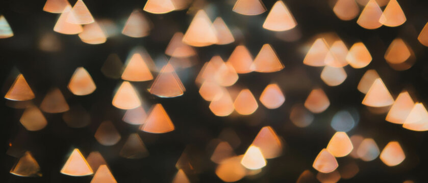 Visually striking overlay texture of light bokeh with triangular shapes on a dark backdrop