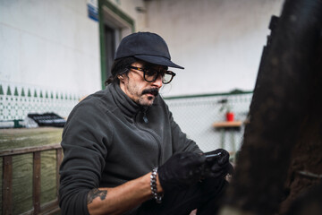 Hombre moreno con gafas poniendo a punto moto de cross para usar en el campo