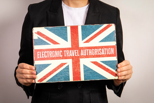 Electronic Travel Authorisation. England flag metal plate in woman's hands