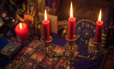 Esoteric concept, some witch stuff on altar. Candle burning on a table