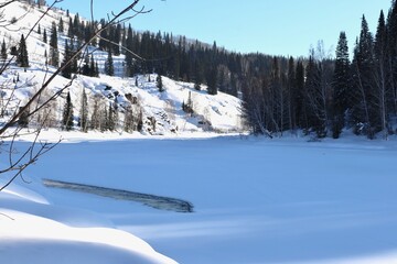thawing on the Malaya Ulba mountain river in winter in Eastern Kazakhstan