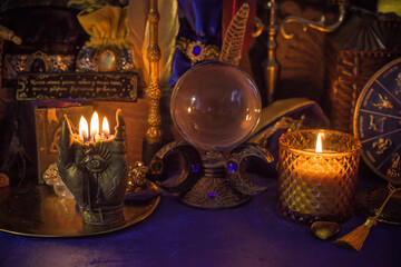 Esoteric concept, some witch stuff on altar. Candle burning on a table