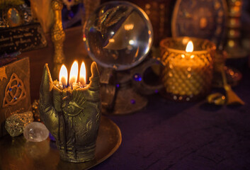 Esoteric concept, some witch stuff on altar. Candle burning on a table