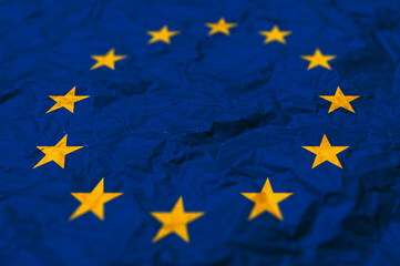 EU flag on paper. The flag of the European Union painted on crumpled craft paper.