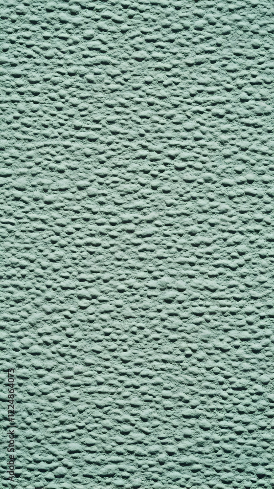 Poster close-up of a textured teal wall surface with raised circular patterns, creates a unique background