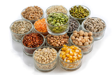 Assorted dried legumes and grains in glass bowls arranged in a decorative pattern