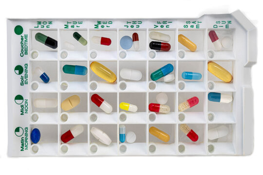 Organized weekly pill organizer with various colored capsules in different compartments for medication management