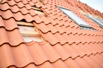 Dachfenster in neuem Hausdach mit roten Dachziegeln