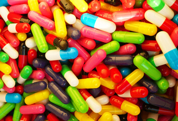 Capsules of pills in Multicolored background. Pharmaceutical pills background, medical tablets, capsules. Medical pill for maintaining, improving health. Healthcare concept, medicine.