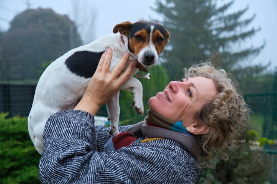 Veterinarian holding a jack russell terrier in a garden