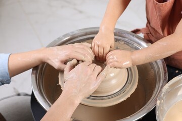 Hobby and craft. Mother with her daughter making pottery indoors, closeup