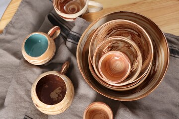 Different beautiful pottery on wooden table, top view
