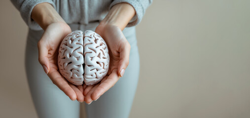 A woman gracefully holding a 3D brain model, representing psychological care, brain health, and stroke awareness. Great for healthcare branding and neurology visuals. Copy Space.
