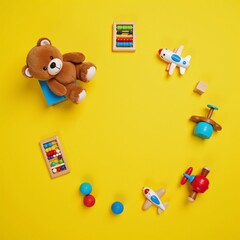 Obraz premium Toy-filled baby playroom scene featuring a teddy bear wood and music toys an abacus a plane pop it fidget toys and colorful blocks arranged against a sunny yellow backdrop in a top-down perspective