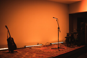 A small chamber stage with musical instruments. A stage without a band. Beautiful warm light on the stage. A stage with instruments in a protestant church. Worship.
