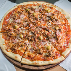 Delicious pizza topped with olives, mushrooms, and ham slices