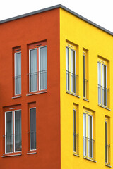Part view of a modern facade with windowas and railings in  lively colors