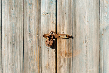 Large barn door with vintage rusty metal padlock.