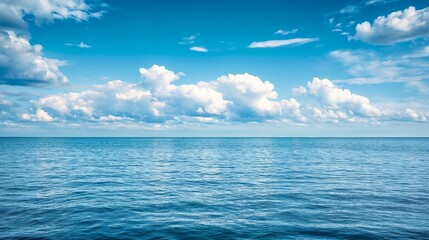 Obraz premium Calm ocean horizon with blue sky and clouds. Perfect for environmental and marine themes.