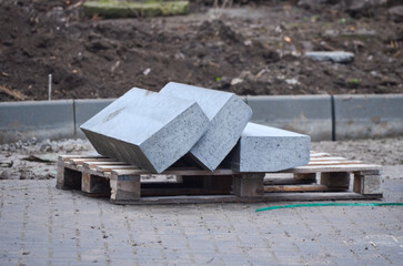 Precast concrete curbs stacked on a pallet for road construction.