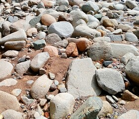 a collection of rocks of various sizes and shapes on the riverbank