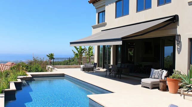 Retractable awning shades a patio with pool. Perfect for showcasing luxury outdoor living and shade solutions.