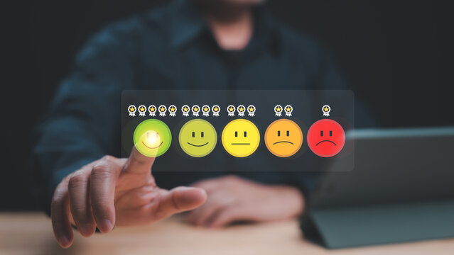 User Engagement Feedback via Emoji Rating, Hand interacts with digital emoji rating system, indicating user satisfaction levels through colorful smile faces and red frown