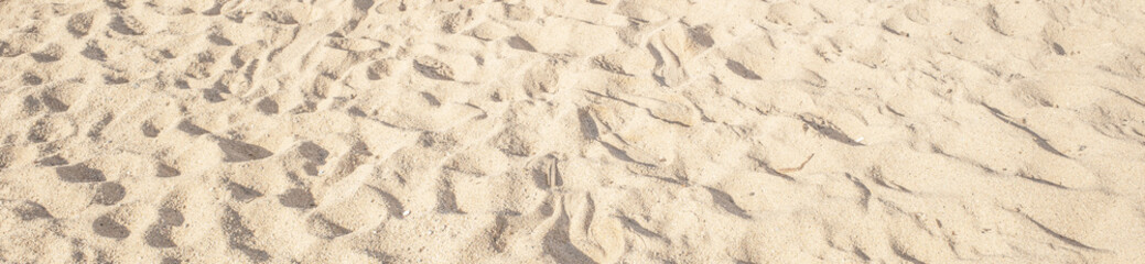Summer beach sand background with natural wave pattern. Sand texture. Sunny gold sandy beach wallpaper