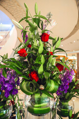 Bouquet flower arrangement of roses lilies and greenery.