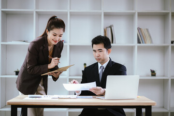 Business team two colleagues discussing new plan financial graph data on office table with laptop and digital tablet.