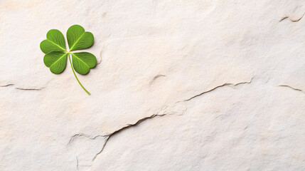 Fresh lucky clover leaf placed on a rough beige rock surface, ideal for St. Patricks Day themes, good fortune concepts, and natural lifestyle branding. Selective focus