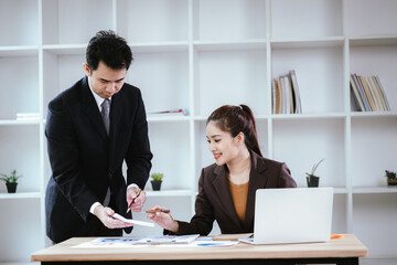 Business team two colleagues discussing new plan financial graph data on office table with laptop and digital tablet.