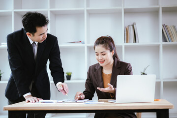 Business team two colleagues discussing new plan financial graph data on office table with laptop and digital tablet.