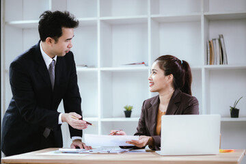 Business team two colleagues discussing new plan financial graph data on office table with laptop and digital tablet.