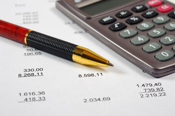 Auf einer Kalkulation liegt ein Taschenrechner mit Kugelschreiber