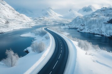 Breathtaking aerial view of a scenic road winding through snow-covered mountains and along a crystal-clear river in the stunning lofoten islands, norway, creating a picturesque winter wonderland