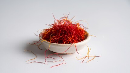 Fototapeta premium bowl filled with saffron threads on a white background. 