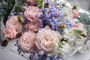 This image showcases a beautiful arrangement of soft pastel flowers, featuring roses and delicate blossoms in a contemporary and elegant display, perfect for various settings.