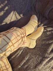 A yellow sock on a bed