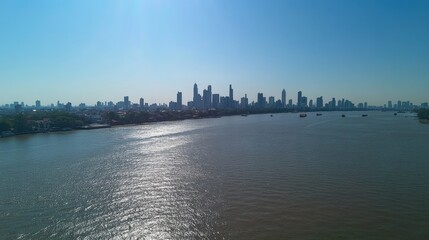 Aerial view of Bangkok skyline with skyscrapers and the Chao Phraya River under a clear blue sky